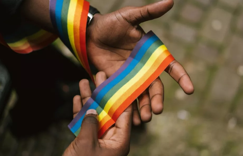 Hand holding a rainbow string