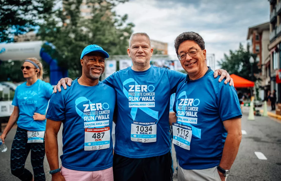 A group of three men in Run/Walk shirts standing together