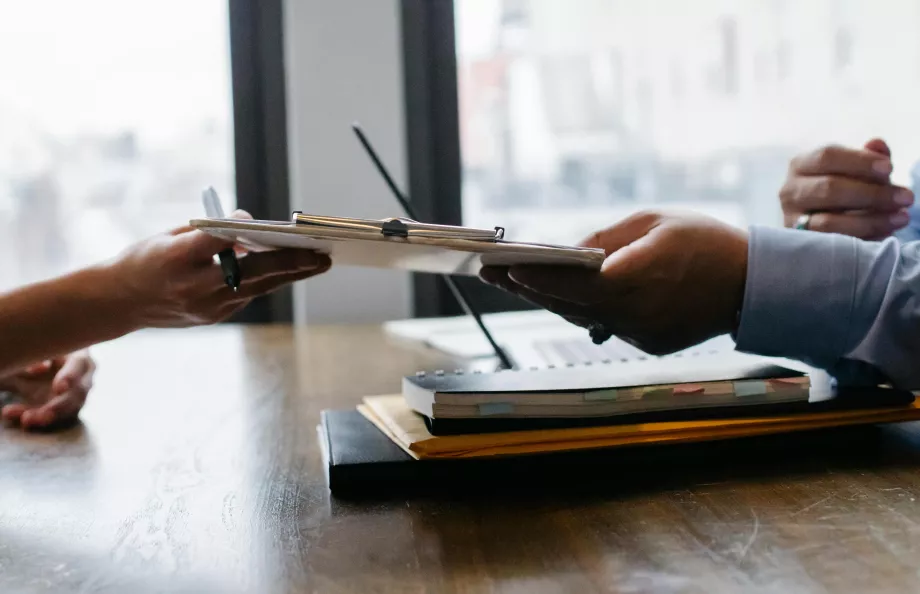 Someone handing over a clipboard