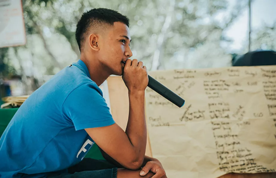 Person sitting down speaking into microphone