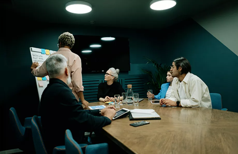 Group of people at desk at work looking at presenter
