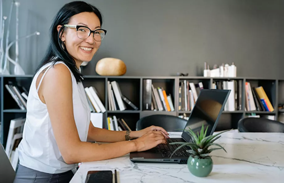 woman wearing glasses on computer in office