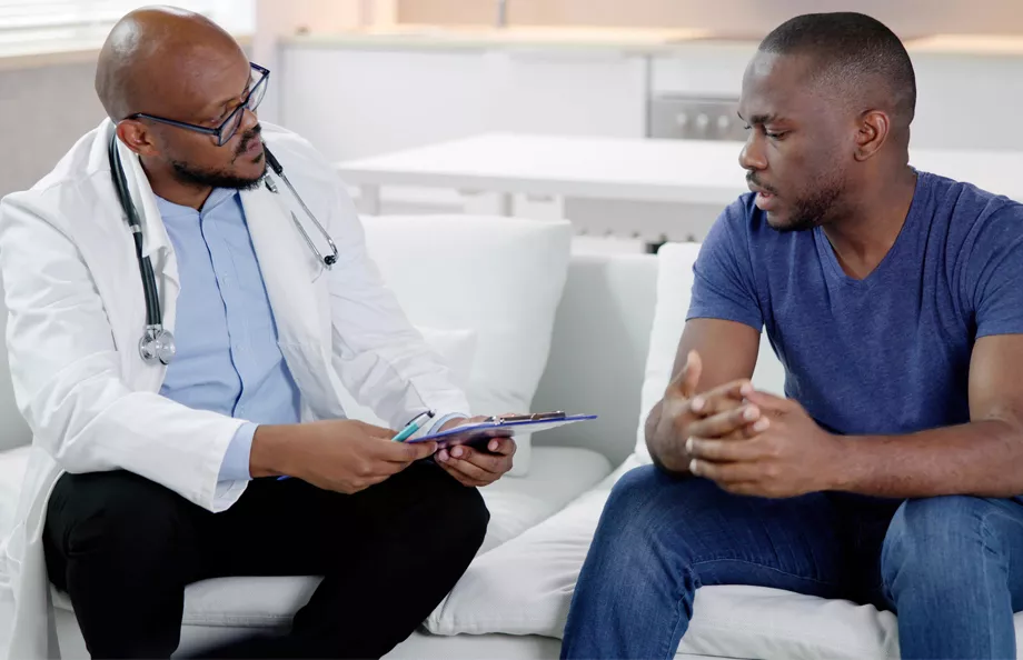 A doctor consults with a patient on a couch, discussing important health information in a calm, supportive setting