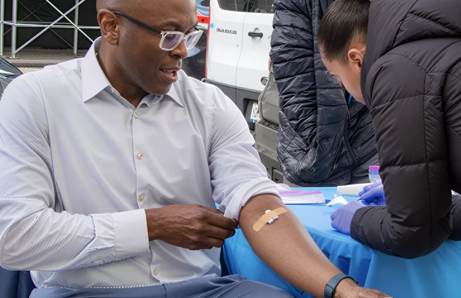 Man sitting at a table getting his blood drawn