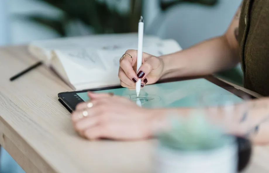 someone drawing on a graphic design tablet